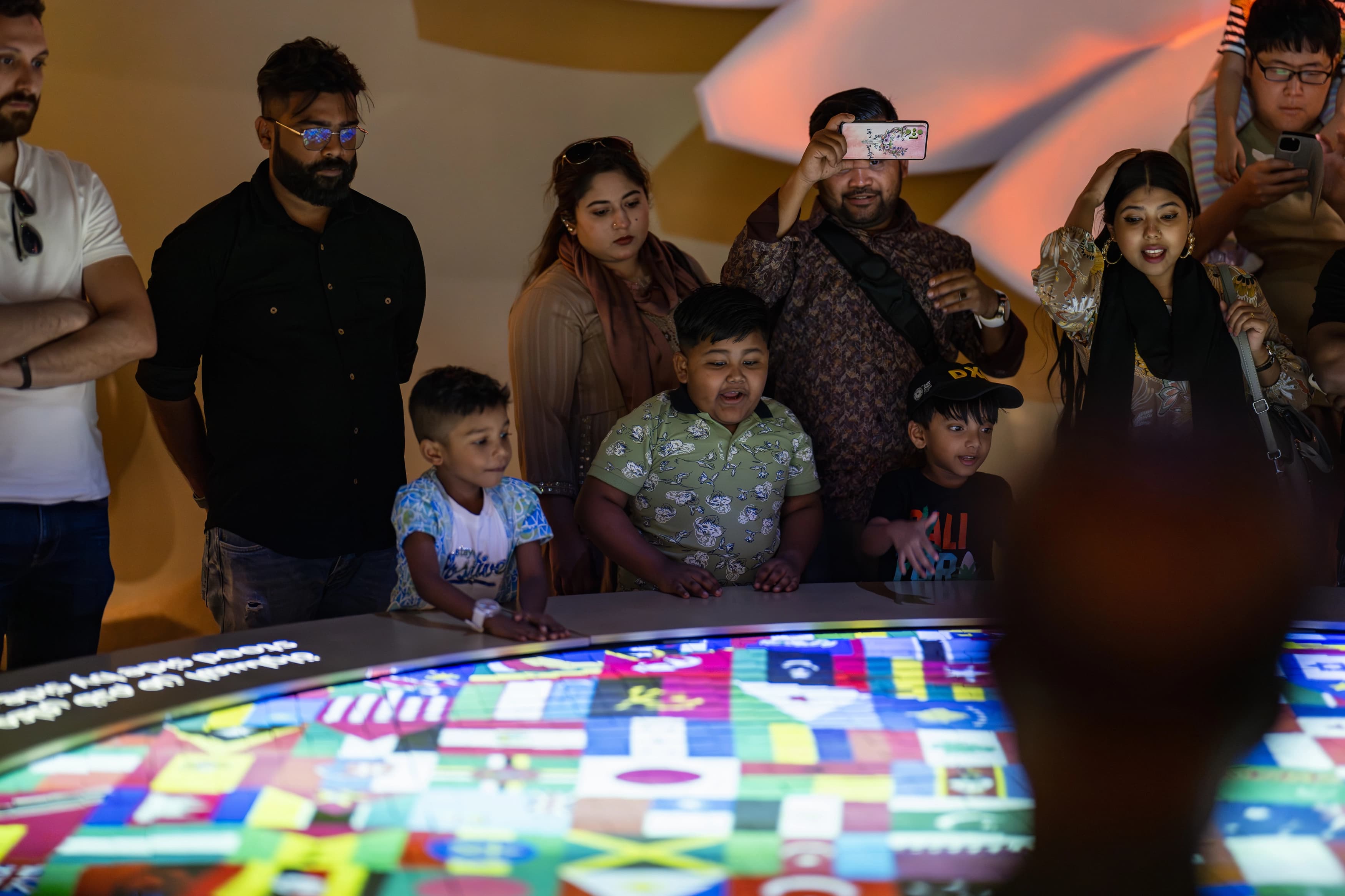 Group of people around a lit table with world flags on it